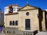 Vista frontal de la Capilla de San Roque bajo un cielo azul.