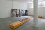 Sala de eventos de MUTA con obras de arte y bancos de madera