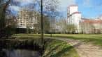 Sendero junto al río Gafos con edificios modernos al fondo