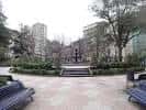 Amplia vista de un sendero pavimentado con bancos y árboles en el Parque de San Lázaro