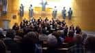 Actuación de un coro en un salón con público