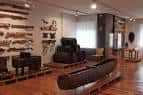Sala de exposición interior con objetos etnográficos y suelo de madera