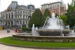 Primer plano de la Fuente de la Escandalera con el Teatro Campoamor al fondo