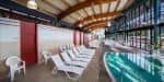 Piscina termal interior con zona de relax y tumbonas