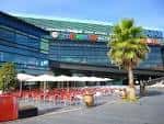 Terraza exterior del Centro Comercial A Laxe con sombrillas y mesas