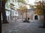 Plaza de Santa Bárbara con la cruz de piedra y árboles otoñales
