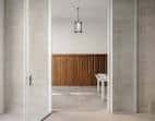 Acceso a sala interior con panelado de madera y luminaria colgante