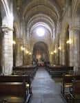 Interior de la nave central de la Colegiata de Santa María del Campo con bancos de madera.