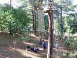 Grupo de personas en la base de las estructuras de escalada del ecoparque
