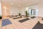 Sala de yoga espaciosa y luminosa con esterillas preparadas