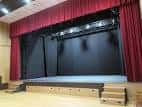 Escenario de la Sala Rebullón con cortinas rojas y luces