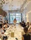 Evento o reunión en sala con mesa larga y personas participando