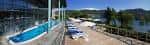 Terraza exterior con piscina y tumbonas con vistas al lago