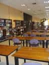 Sala de lectura con mesas y estanterías en el interior de la biblioteca