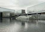 Vista exterior de los edificios modernos de la Fundación MOP con reflejos en el agua