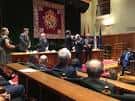 Salón de actos con mesa presidencial y público durante un evento