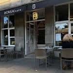 Entrada exterior de Bonsai Café con mesas en la acera