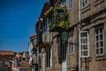 Vista de una calle empedrada con edificios de piedra y balcones en Santiago de Compostela