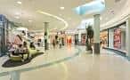 Pasillo interior del centro comercial con tiendas y zona de descanso