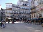 Vista diurna de la Praza da Constitución con edificios históricos y terrazas animadas