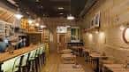Interior acogedor de The Othilio Bar con paredes de madera y barra larga