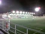 Vista nocturna del campo de fútbol municipal con iluminación