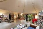 Amplio espacio interior de la librería con personas y estanterías