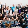 Grupo de personas sonriendo y saludando en un evento de Hack A Boss