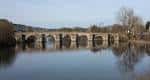Puente romano sobre el río Miño con reflejo en el agua