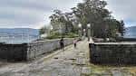 Puente de piedra que conecta las dos partes de la Isla de San Simón, con personas caminando