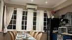 Interior de restaurante con mesas preparadas y ventanas con cortinas