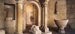 Interior de sala con columnas de piedra y elementos arqueológicos
