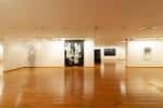 Amplia sala interior con suelo de madera y obras de arte en las paredes