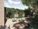 Terraza exterior ajardinada con mesas y sillas