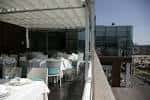 Terraza cubierta con mesas y vistas al entorno marítimo
