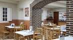 Amplio salón comedor de Casa Fidel O'Pulpeiro con mesas de madera y arcos de ladrillo