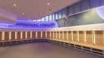 Interior de un vestuario moderno con taquillas y bancos iluminados