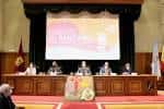 Mesa de ponentes en un congreso o conferencia con pantalla de proyección