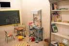 Zona de juegos infantil con pizarra y estanterías de libros
