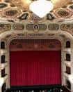 Perspectiva del escenario y el telón rojo desde un palco superior del teatro