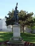 Estatua en los Jardines de la Maestranza rodeada de césped y árboles