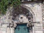 Entrada principal ornamentada con arco de piedra y puerta de madera
