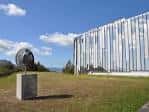 Fachada de edificio universitario con escultura en el exterior