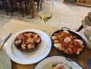 Variedad de tapas y bebidas servidas en una mesa de la Taberna Kamelia