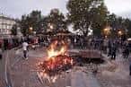 Gran hoguera en un campo de fiesta con gente celebrando