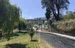 Sendero arbolado con viaducto ferroviario al fondo