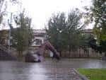 Escultura de figura reclinada en la Plaza de la Estrella en un día lluvioso