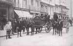 Escena histórica de calle con carruajes y personas en el Cantón Grande.