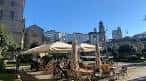Terraza exterior de la Taberna Kamelia con sombrillas y clientes en un día soleado