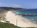 Extensa Playa de Barrañán con dunas y formaciones rocosas en el mar